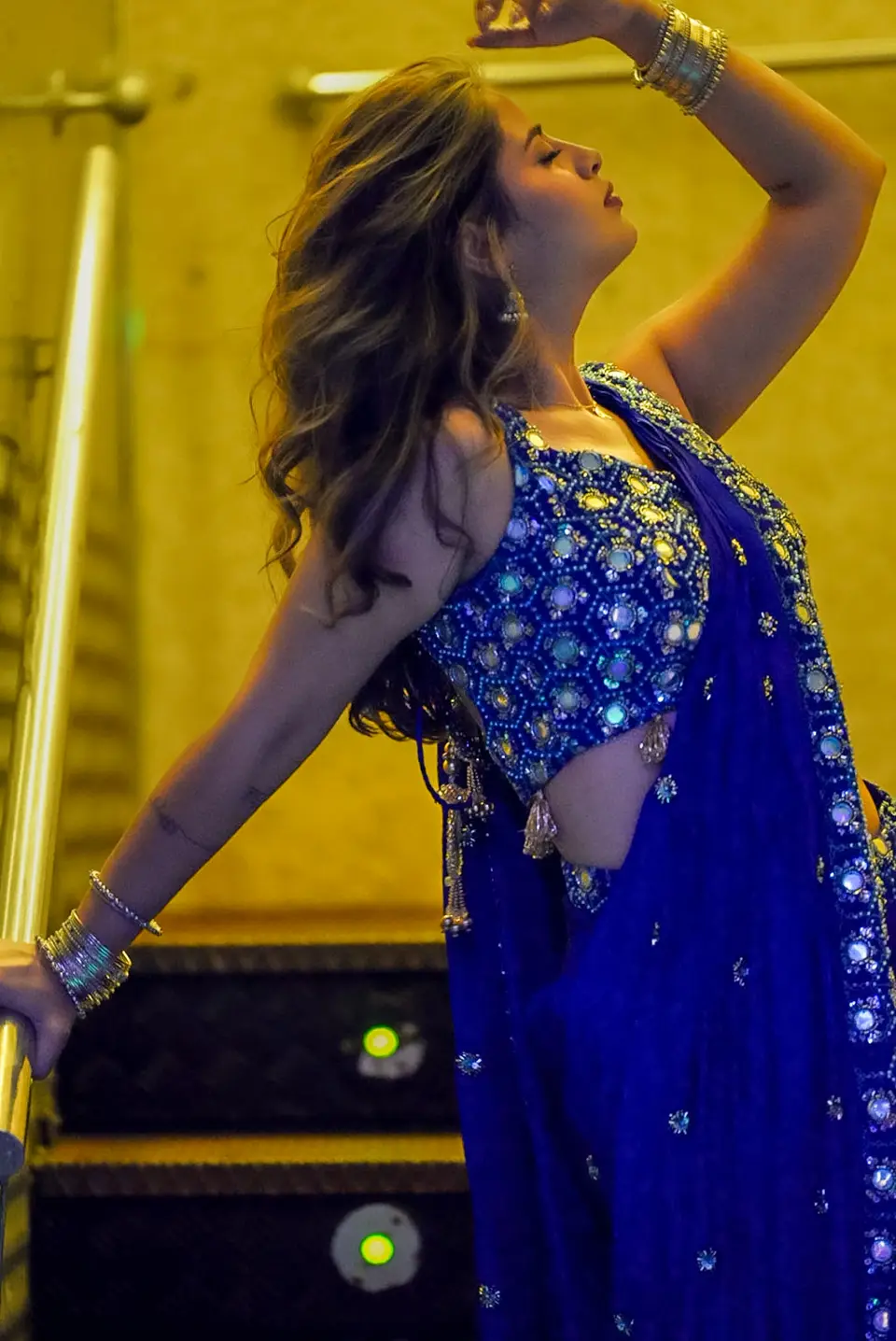 Performer in a blue embellished outfit during an indoor celebration