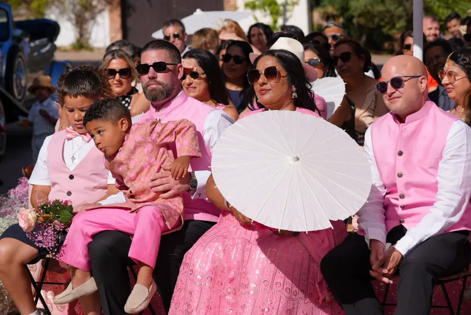 Wedding guests seated outdoors in coordinated pink attire