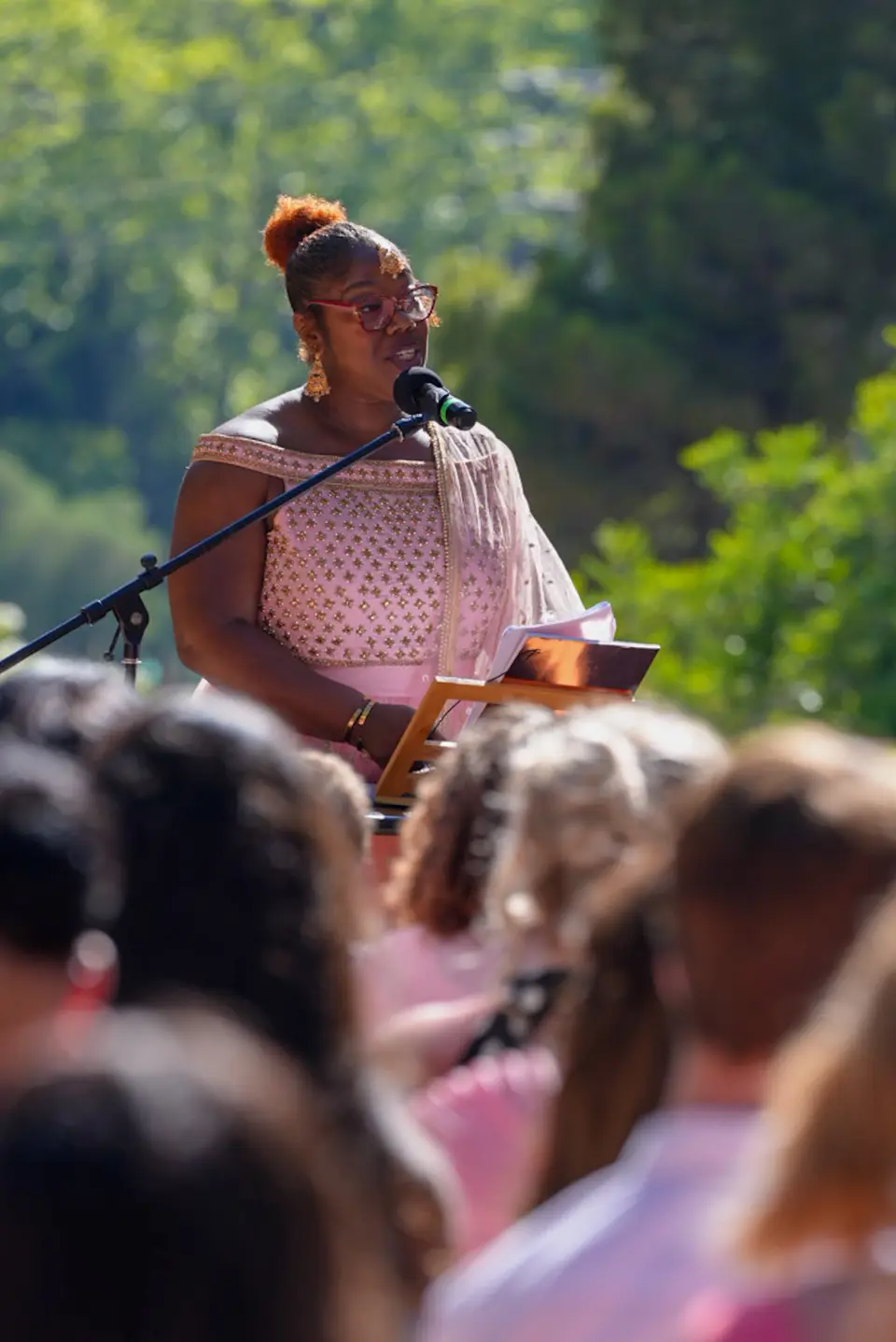 Singer speaking into a microphone during an outdoor wedding ceremony