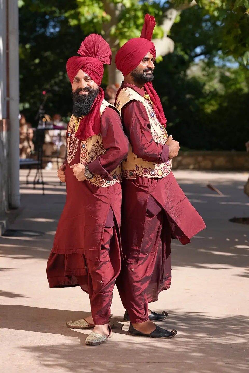 Traditional performers in red turbans standing outdoors